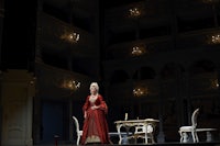 a woman in a red dress standing on a stage